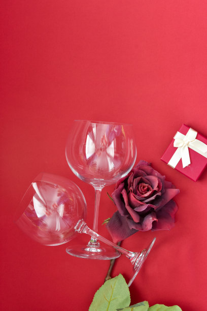 两个红色背景的空酒杯。平面布局，俯视图，复制空间，最小的情人节浪漫的概念。图片下载