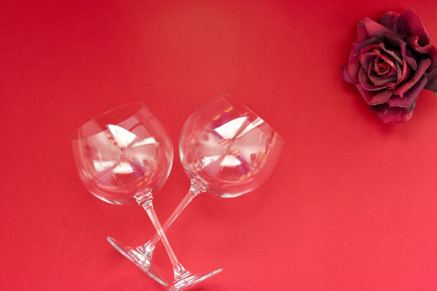 两个红色背景的空酒杯。平面布局，俯视图，复制空间，最小的情人节浪漫的概念。图片下载