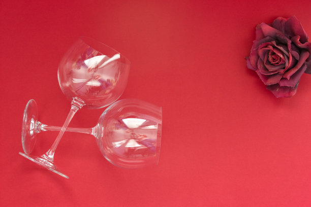 两个红色背景的空酒杯。平面布局，俯视图，复制空间，最小的情人节浪漫的概念。图片下载