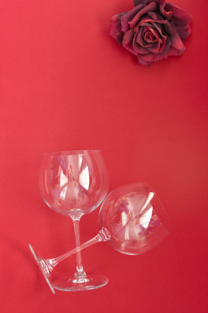 两个红色背景的空酒杯。平面布局，俯视图，复制空间，最小的情人节浪漫的概念。图片下载