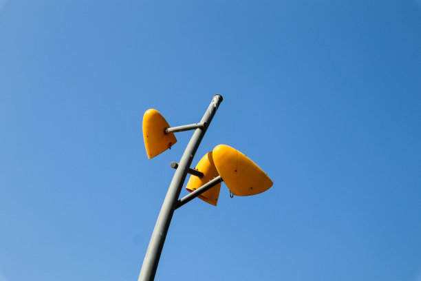 城市灯杆与三盏黄色灯和清晰的天空背景图片下载