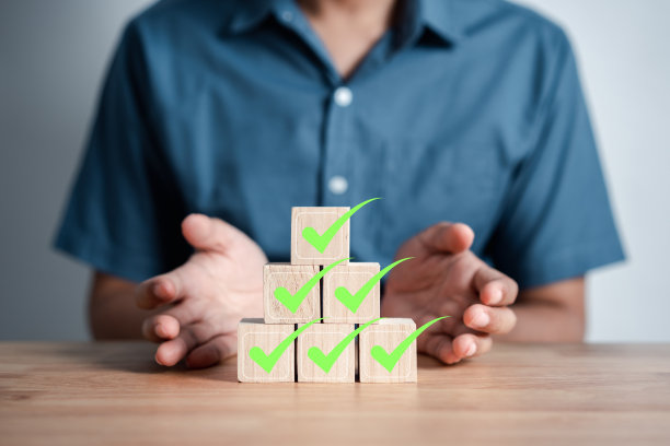 商人在木块上堆放绿色正确图标，用于文件和项目审批、检查、标记。图片下载