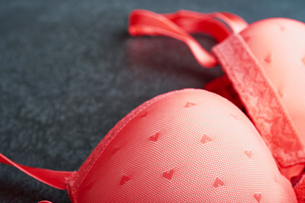 红色性感内衣和内裤在盒子上的黑色背景。女人性感内衣套装与玫瑰和香水。妇女节或情人节的礼物创意与复制空间。不论是对男人还是对他来说都是惊喜。俯视图图片下载