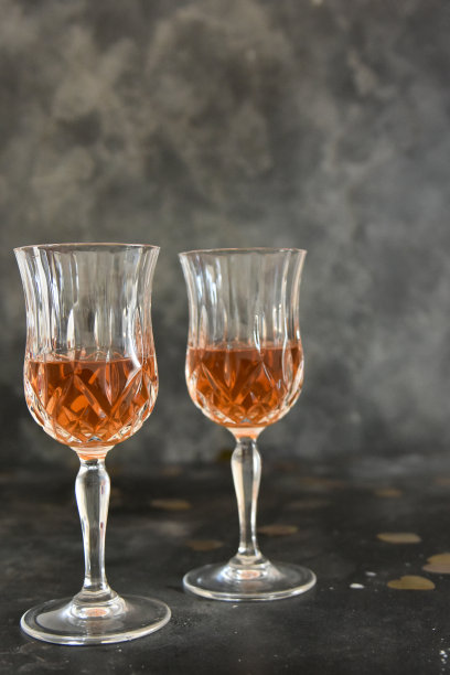 合上两杯酒和黑色背景上的小红心。副本的空间。节日派对概念。图片下载