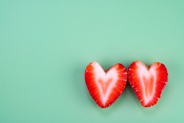 心形草莓孤立在柔软的绿色背景图片下载