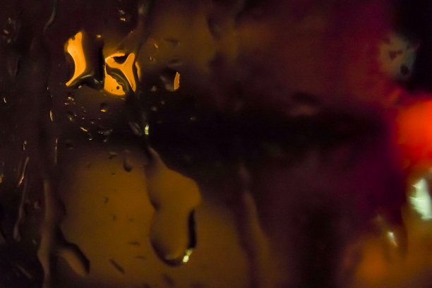 夜间雨滴在窗户上的特写。背景，个人博客等。模糊的效果。图片下载