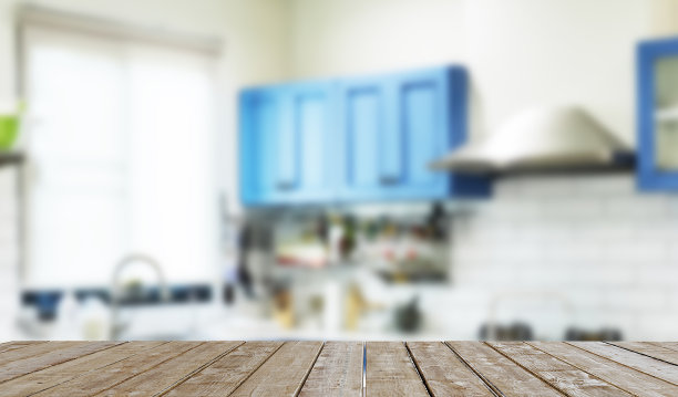 顶部木桌的产品或食物蒙太奇在前面的模糊厨房背景。图片下载