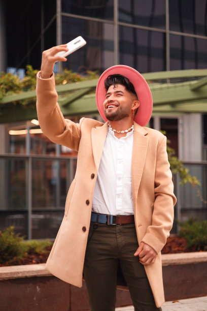 年轻的西班牙男子在现代户外自拍，时髦和现代风格图片下载