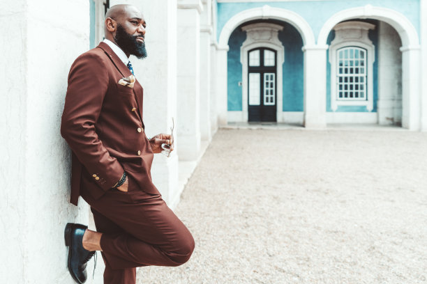 一个优雅的男人靠在墙上图片下载