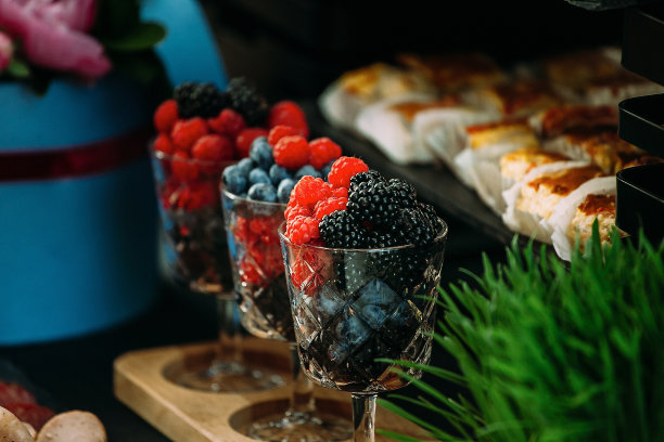 玻璃杯上放着浆果，节日的桌子上装饰着青草。图片下载