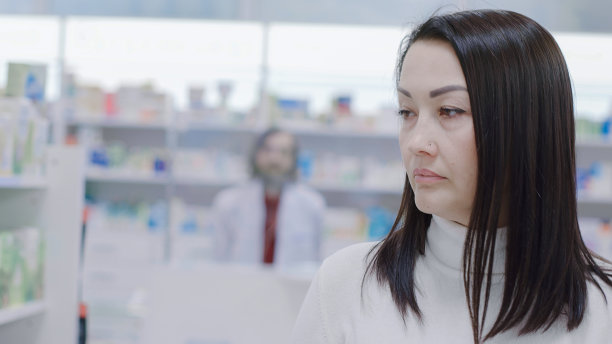 一名妇女环顾药房里的药品和化妆品货架图片下载
