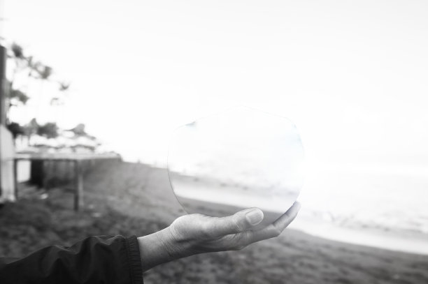 人手里拿着空的透明圆形玻璃。图片下载