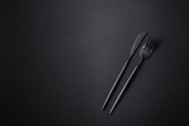 金属厨刀和叉子在黑暗的纹理混凝土背景图片下载