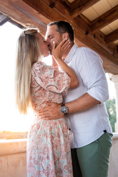 日落时分，一个女人在地中海阳台上亲吻她的男人图片下载