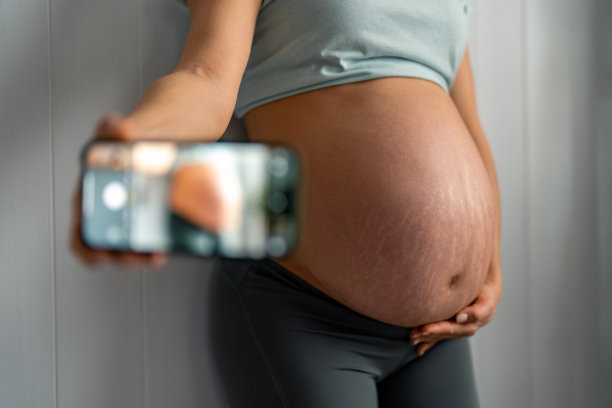 一位不认识的孕妇正在拍她的大肚子图片下载