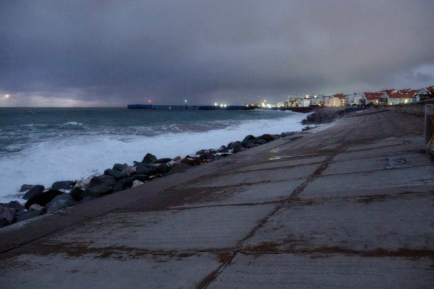 晚上的照片。破旧的码头和满月的大海。夜间海上冲浪。图片下载