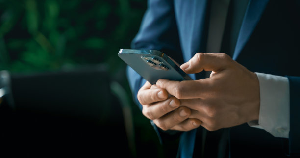 西装革履的商人，手里拿着手机。男人打字，使用社交网络。检查消息。洽谈业务。现代办公室。总经理、首席执行官。呼叫合伙人。计划工作天图片下载