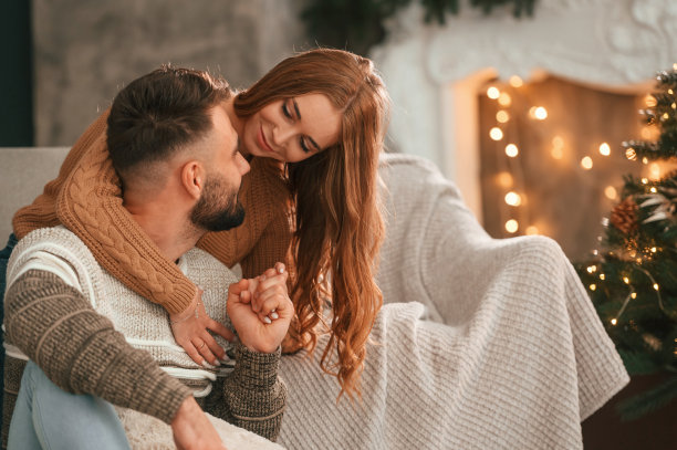 拥抱彼此。可爱的小情侣正在家里庆祝新年图片下载