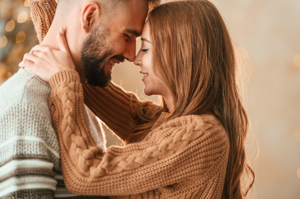 站着拥抱。可爱的小情侣正在家里庆祝新年图片下载