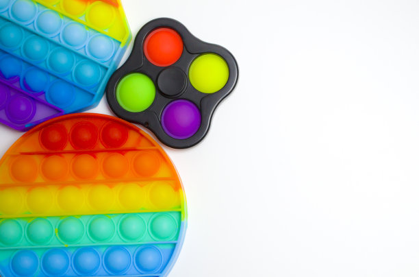 彩色潮流抗压力感觉玩具指尖推流行它和简单的酒窝在蓝色背景图片下载