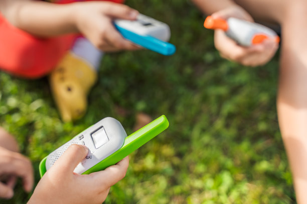 小孩子，女孩玩对讲机。带频道的对讲机。侦探和间谍的游戏。孩子们在远处交谈，传递信息。在森林、公园、徒步旅行中与家长交流。寻找迷路的人图片下载