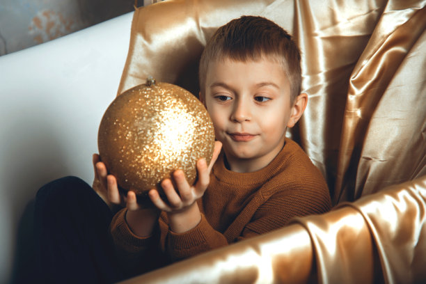在圣诞、新年背景下，一个穿着黄色毛衣的欧洲男孩坐在装饰浴室里图片下载
