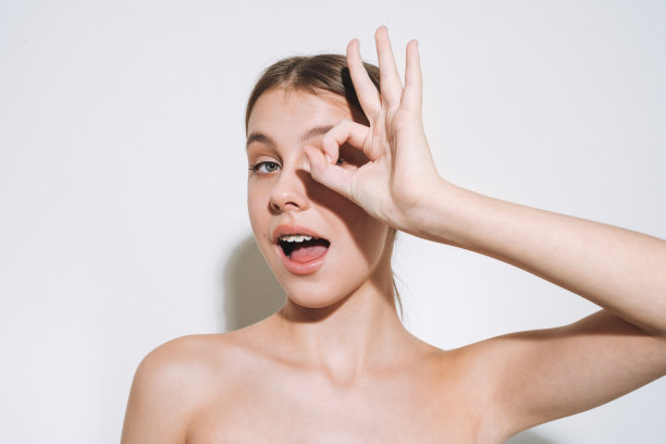 美丽的肖像有趣的年轻女孩与新鲜的皮肤，青少年与牙套在白色背景隔离图片下载