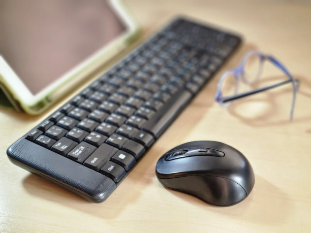 桌上有平板电脑、电脑键盘、鼠标和眼镜。图片下载