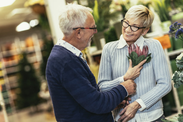 一对老年夫妇正在花园中心挑选鲜花。图片下载