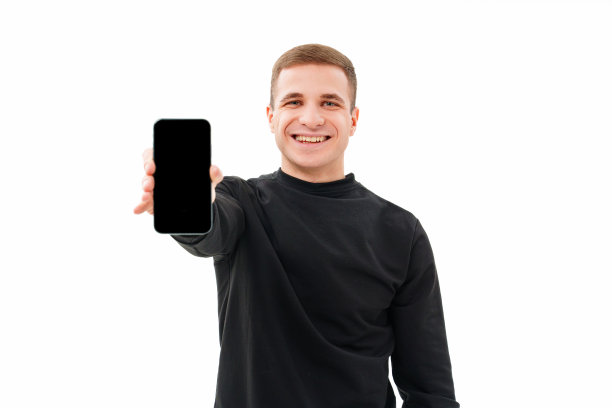 一名身穿黑色衣服的男子在白色背景上展示智能手机的屏幕。图片下载