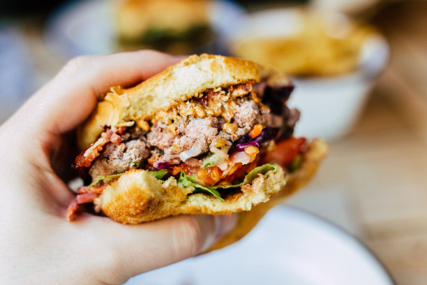 男子拿着美味的新鲜火焰烤汉堡在餐厅- POV镜头图片下载