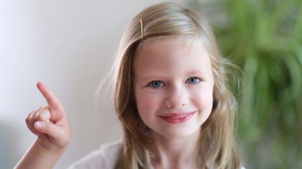 欢快的微笑的孩子女孩的肖像指向一边图片下载