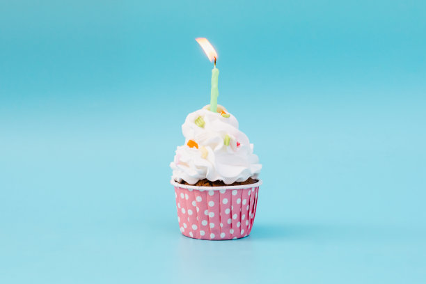 美味的杯子蛋糕在蓝色背景与复制空间图片下载