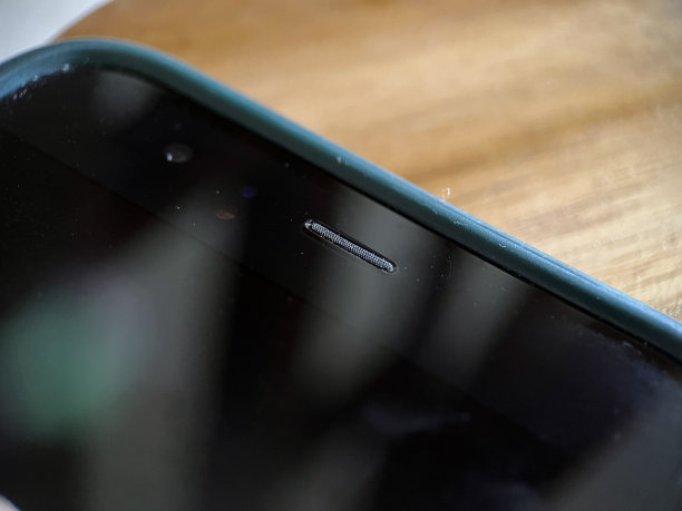 木制背景的前智能手机扬声器图片下载