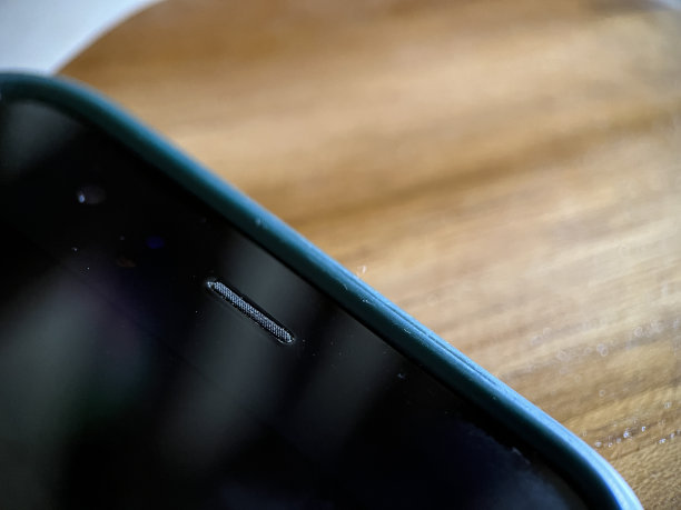 木制背景的前智能手机扬声器图片下载