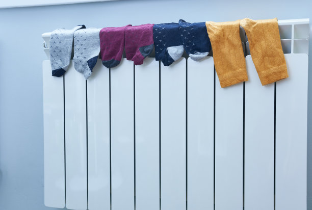 袜子放在房间里的白色暖气片上。干的事情。图片下载