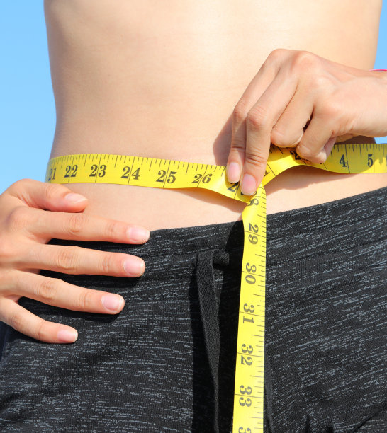 女生腹部腰围测量用黄色卷尺和寸尺图片下载