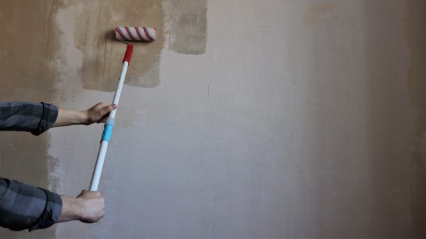 用长柄滚轮在房间墙壁上打底图片下载