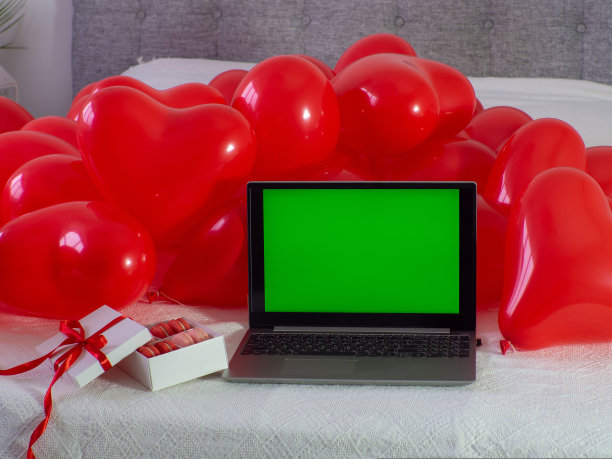 盒子里有马卡龙饼干，床上有彩色键屏幕的笔记本电脑图片下载