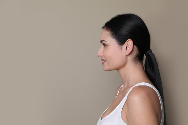 年轻女子的侧面肖像灰色背景。文本空间图片下载