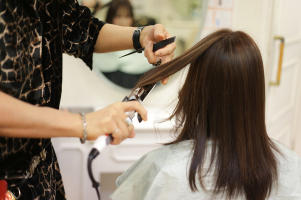 男理发师正在给女人熨头发图片下载