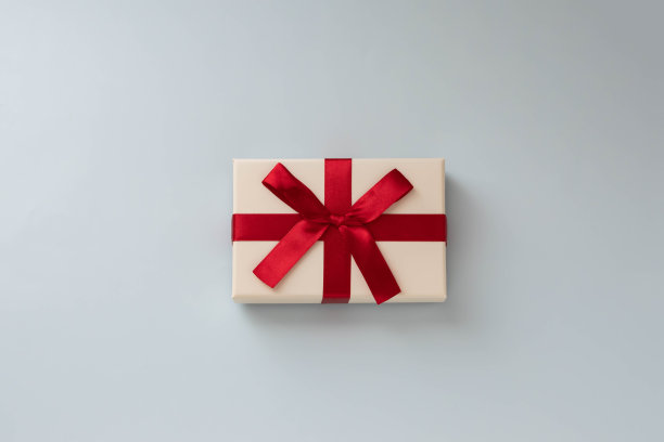 一幅在平面构图中赠送和接收红丝带礼物的图像，一颗深情的心。图片下载