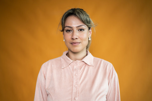 一个年轻女子的肖像在橙色的背景图片下载