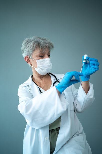 在摄影棚里，医生戴着防护口罩准备注射图片下载