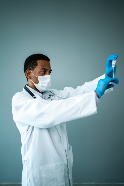 在摄影棚里，医生戴着防护口罩准备注射图片下载