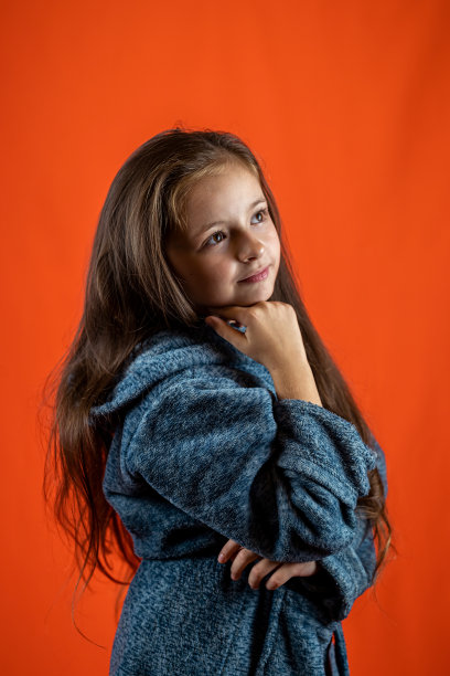 一个美丽的小女孩穿着灰色浴袍去洗澡的肖像。图片下载