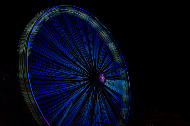 晚上，游乐园里的轮毂在灯光下旋转。图片下载