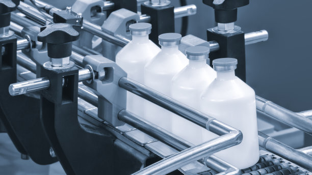 医药工业中，药厂生产线上的机器传送带正在将药片装入瓶中。有选择性的重点。图片下载