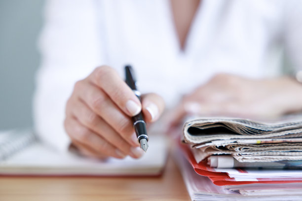 一个女商人的手正在看报纸的特写镜头图片下载