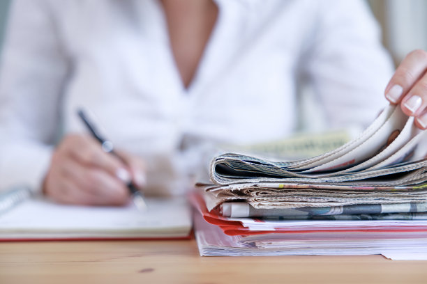 一个女商人的手正在看报纸的特写镜头。图片下载